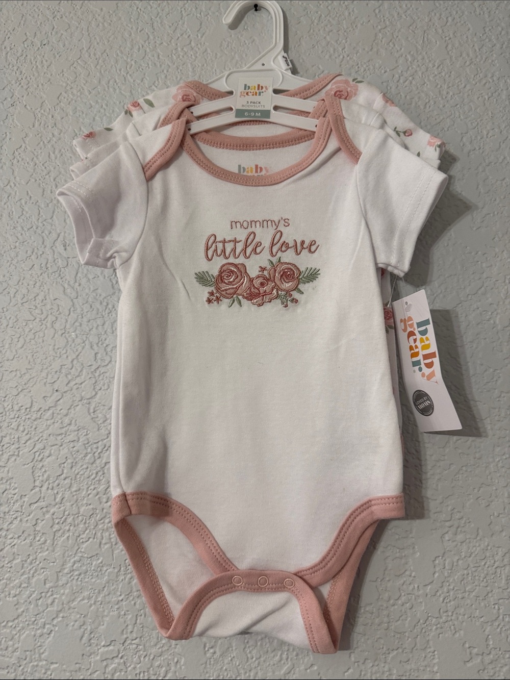 NWT- Baby Gear White Onesie 3 pack- white, pink, and floral designs.